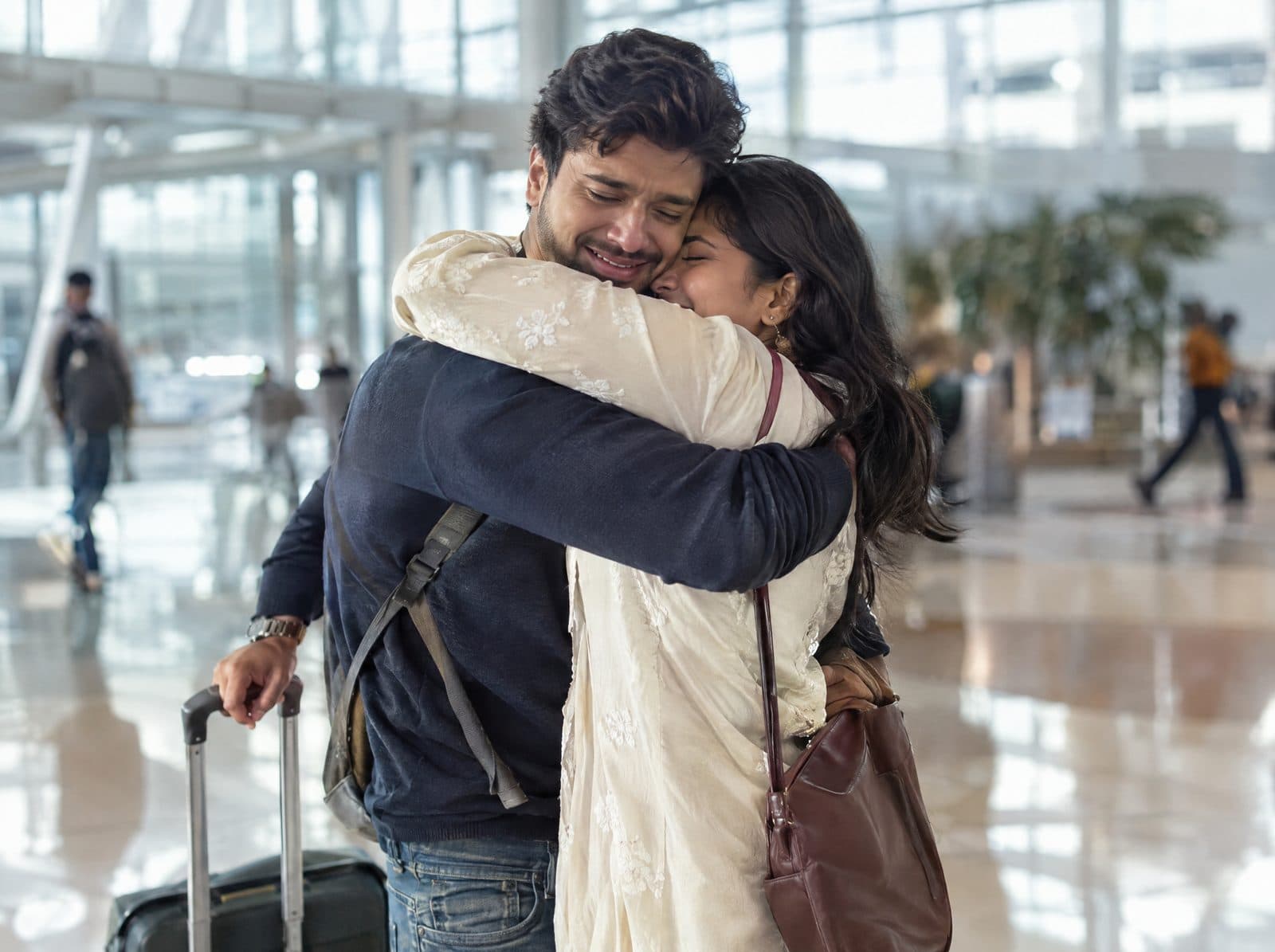 A couple hugging in an airport arrivals hall